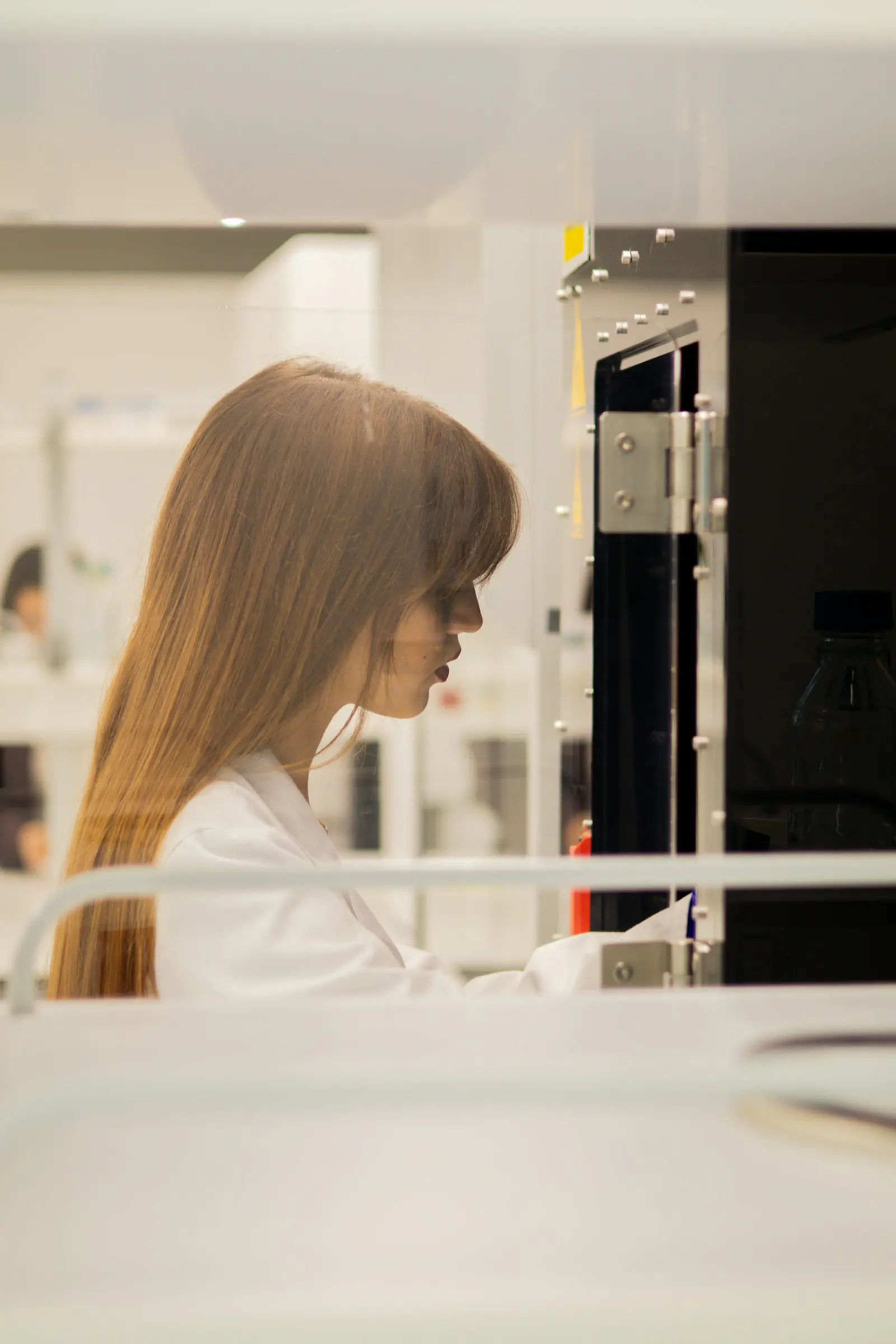 Scientist in a white lab coat working at the bench in a research laboratory